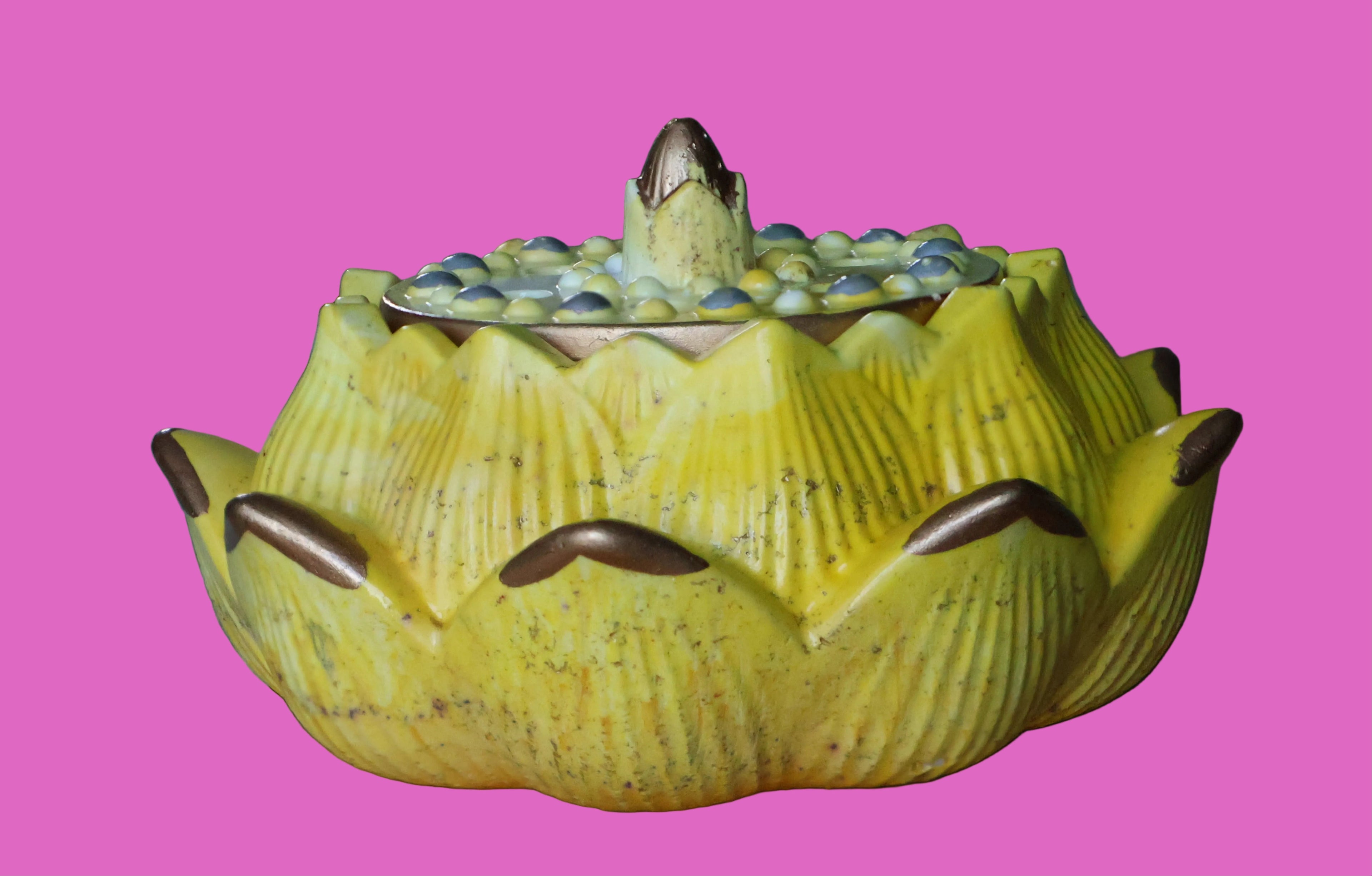 Yellow cement lotus flower on a wooden surface with a blurred background