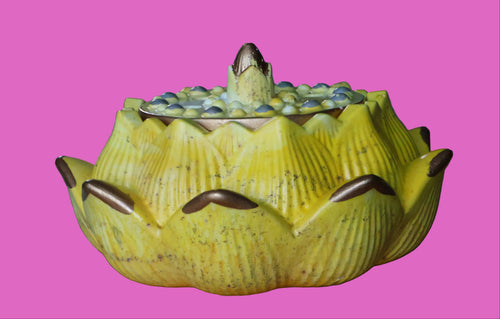 Yellow cement lotus flower on a wooden surface with a blurred background