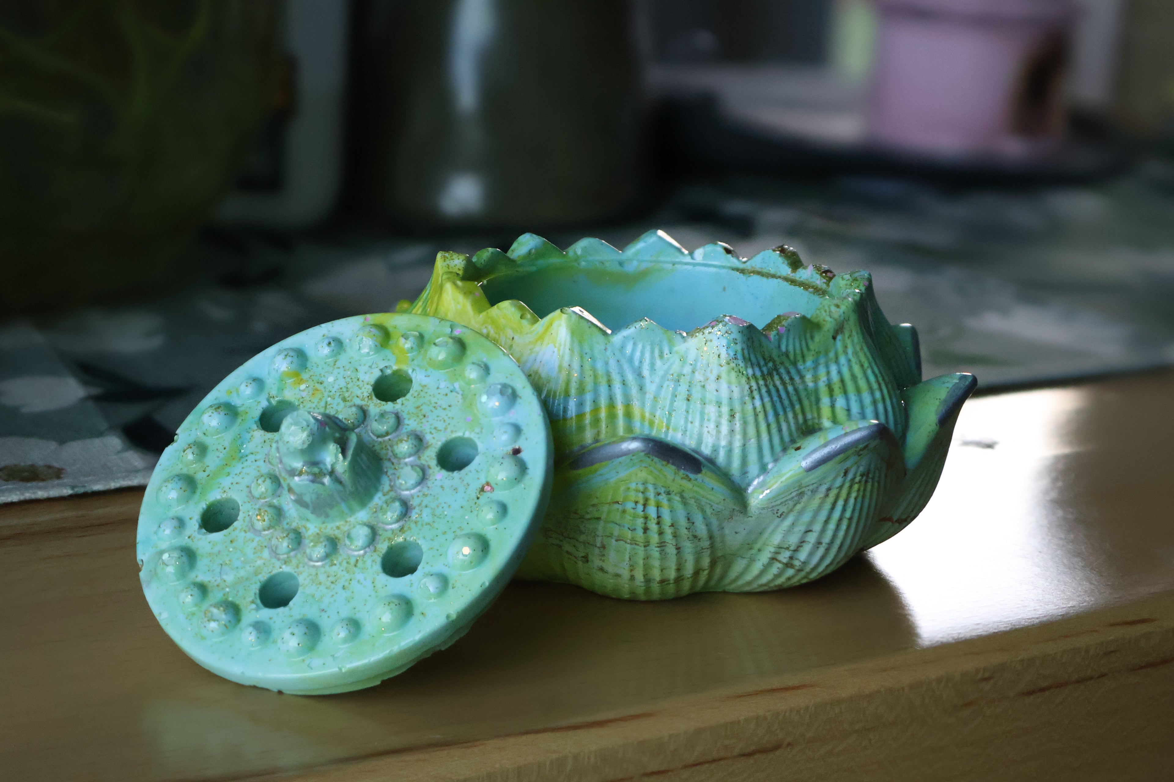 Green cement lotus flower with a textured top on a wooden surface