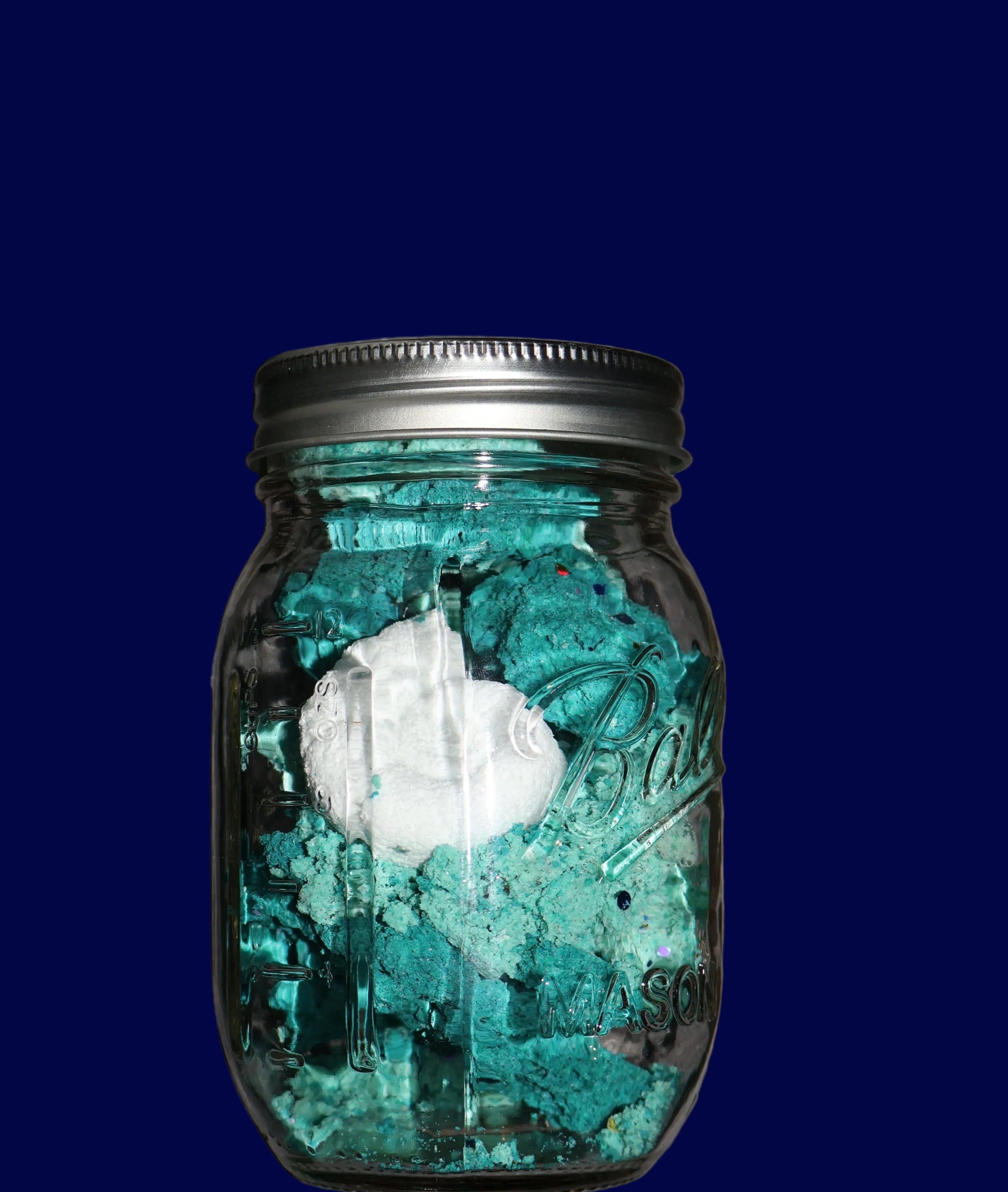 Small jar with green contents on a textured surface